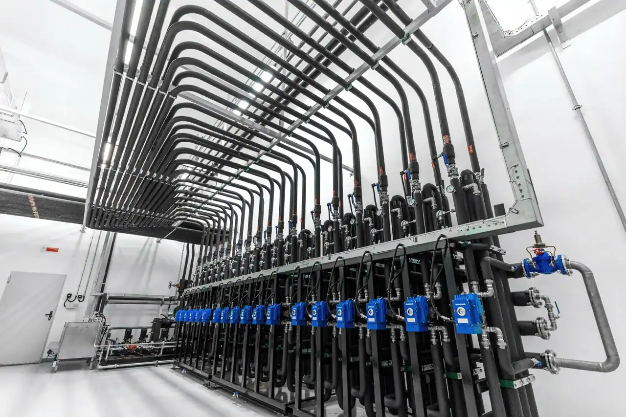 Industrial piping system with valves and control units in a clean facility.