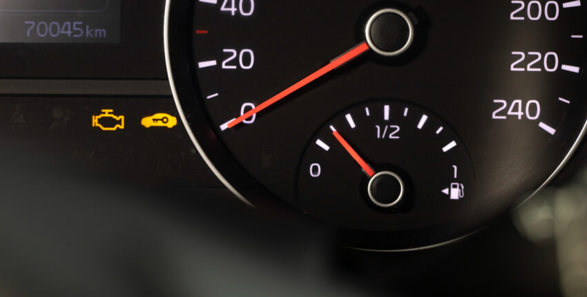 Car dashboard with check engine warning light illuminated, indicating potential engine issues.