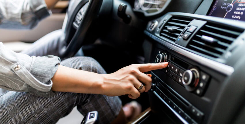 Person adjusting vehicle climate control in a diesel truck dashboard.