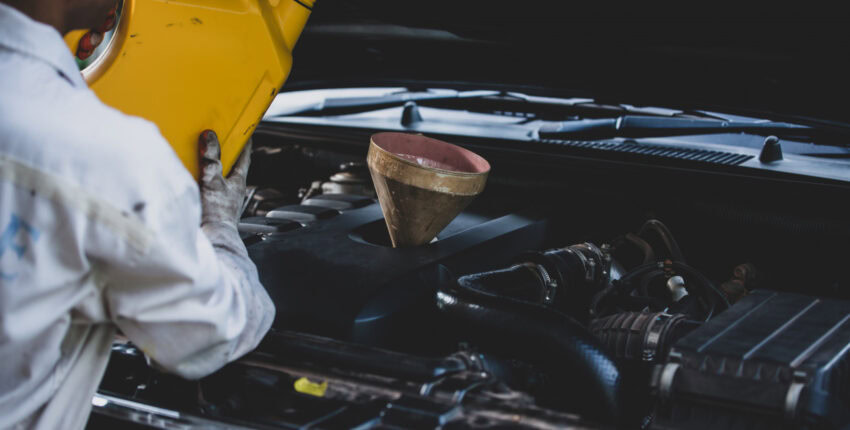 Technician checking engine oil in diesel engine bay.