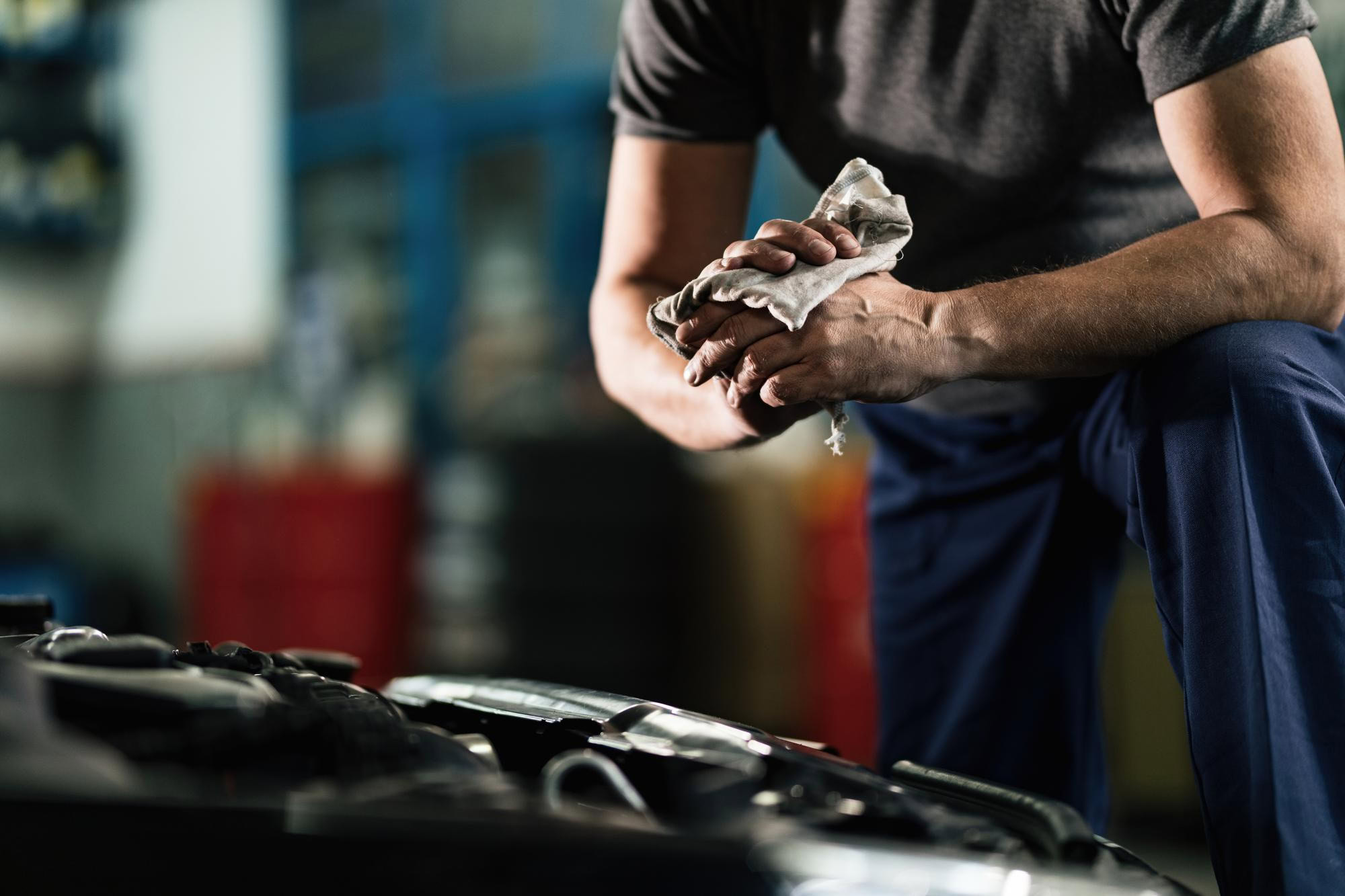 Mechanic rubbing his hands with an oil rag