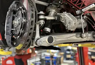 Close-up of automotive suspension and drivetrain components in a European vehicle.