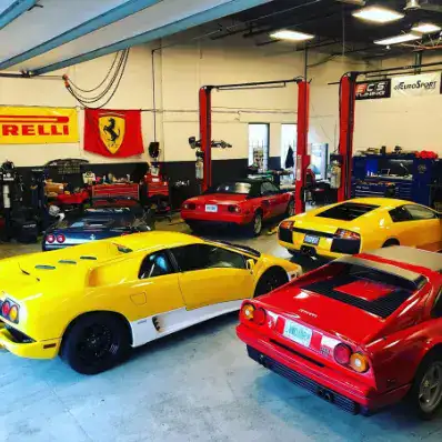 European automotive classic cars in a garage with lifts and tools.