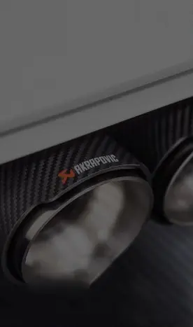 Close-up of high-performance exhaust pipes with carbon fiber finish.