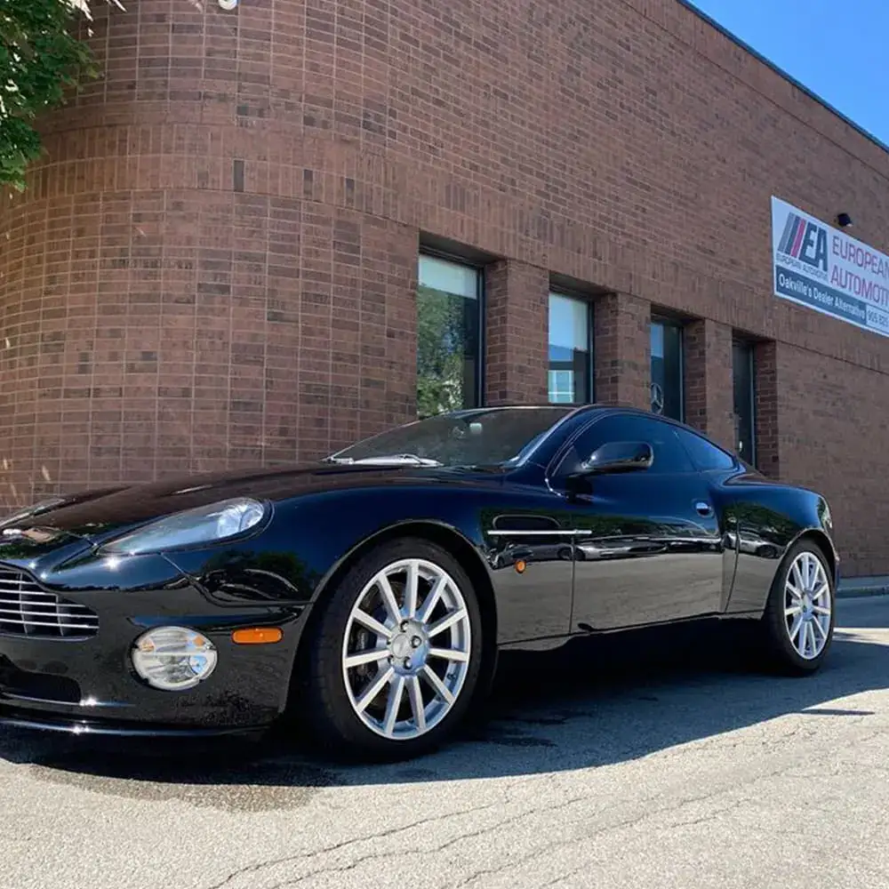 Black luxury sports car parked outside European Automotive building.