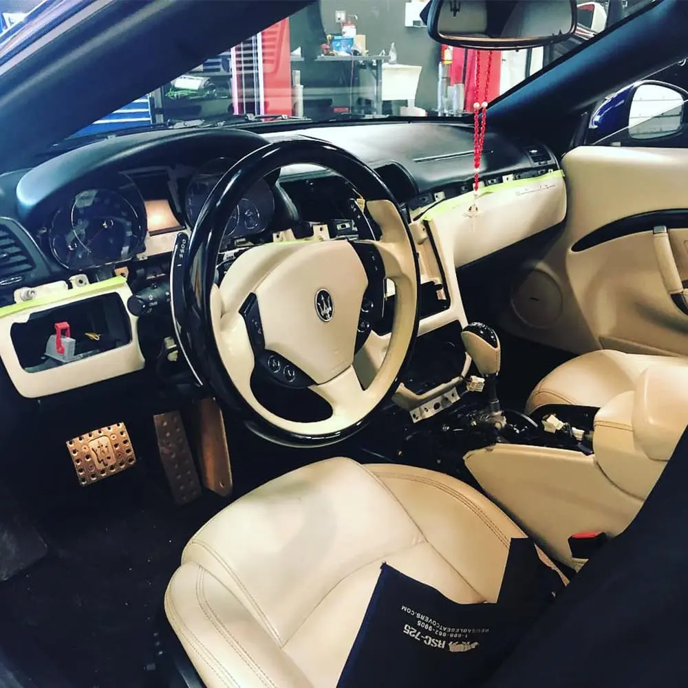Interior view of a European car with beige seats and black dashboard.