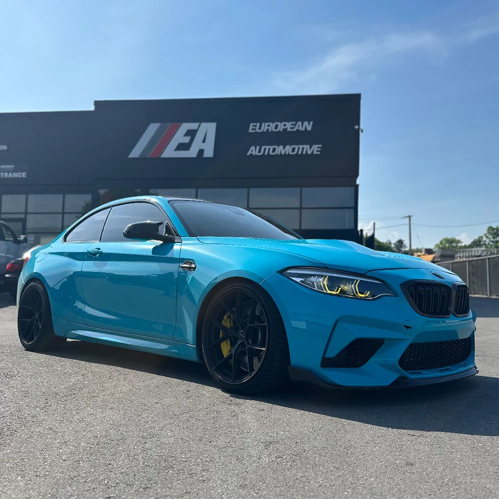 Blue sports car parked outside European Automotive dealership.