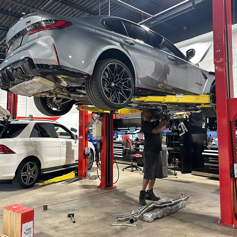 Modern car repair workshop with a vehicle lifted on a hydraulic lift.