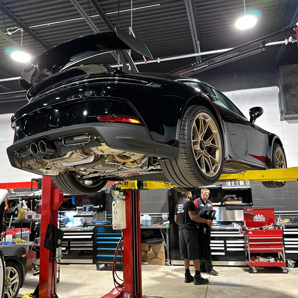 Black sports car on lift at European Automotive workshop in Canada.