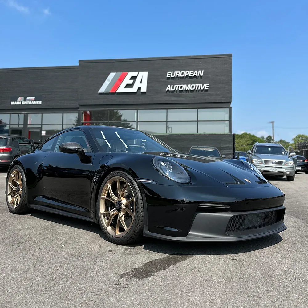 Black sports car parked outside European Automotive dealership.