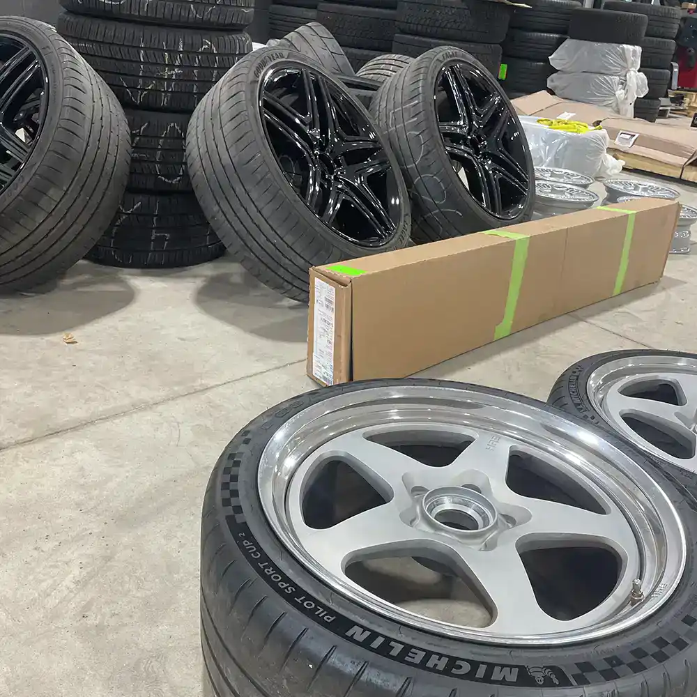 Stacked tires and alloy wheels at European Automotive store.
