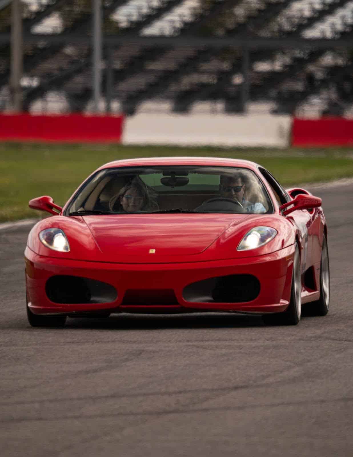 Red sports car on race track at European Automotive event.