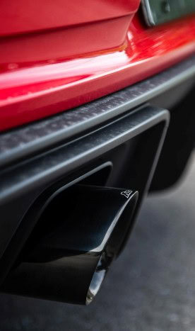 Close-up of a car's exhaust pipe on a red vehicle.