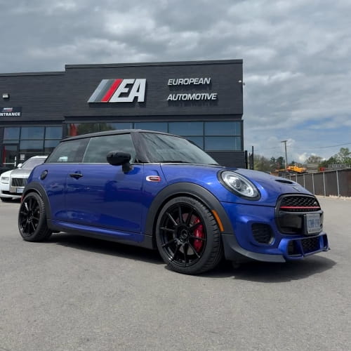 Blue Mini Cooper parked outside European Automotive dealership.