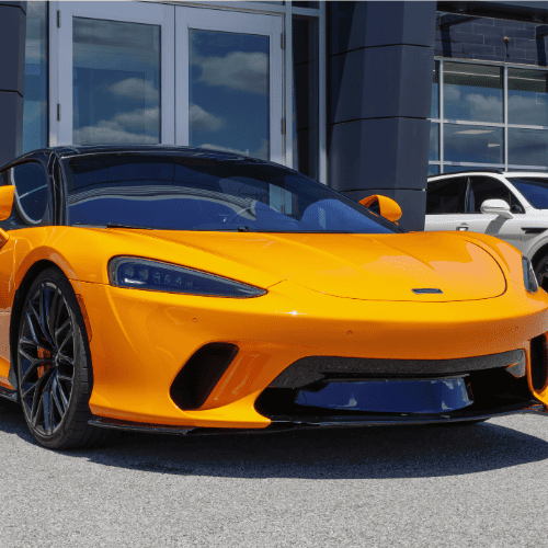 Bright yellow sports car parked outside European Autoworks service center.