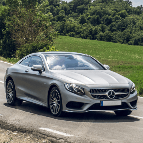 Silver Mercedes-Benz coupe on scenic roadside, vehicle servicing by European Autoworks.