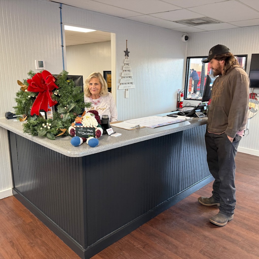 Customer and staff at the Express Tire and Auto Service reception desk during holiday season.