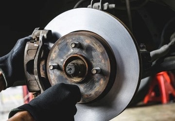 Brake rotor being inspected and replaced for optimal vehicle safety and performance.