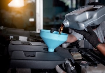 Oil change being performed on a vehicle engine for maintenance.