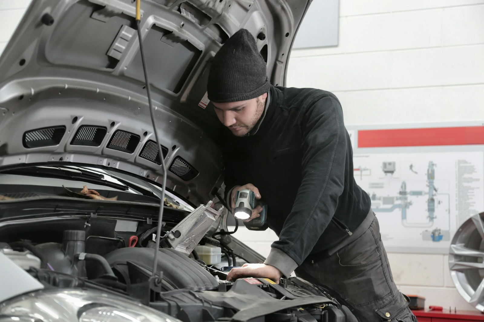Skilled mechanic performing engine diagnostics and repair in an auto repair shop.