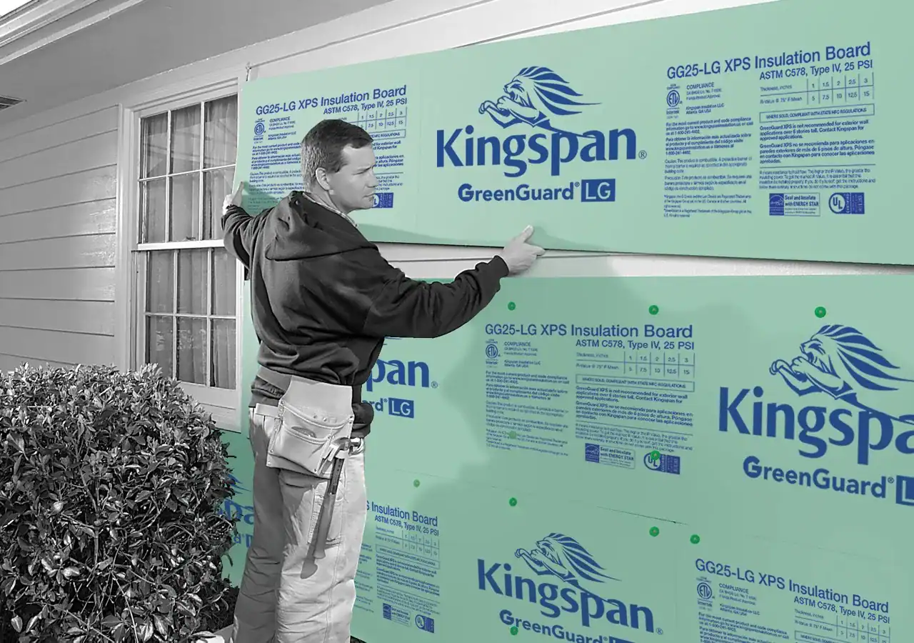 Man applying Kingspan GreenGuard LG insulation panels to exterior wall.