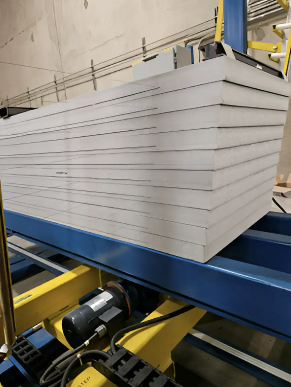 High-quality foam sheets stacked on industrial conveyor, ready for processing.