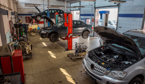 Auto repair shop with cars on lifts and tools in a professional garage setting.