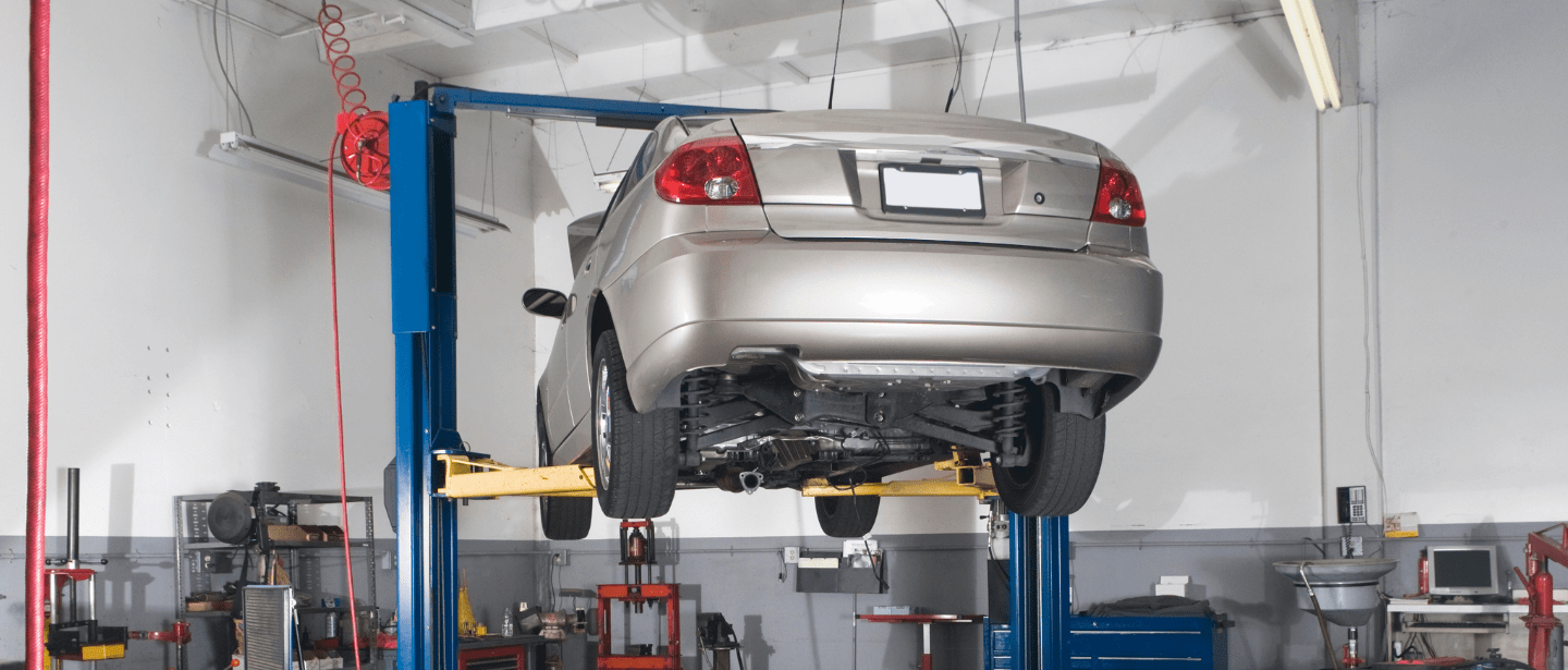 Auto repair lift with a car elevated for maintenance or inspection.
