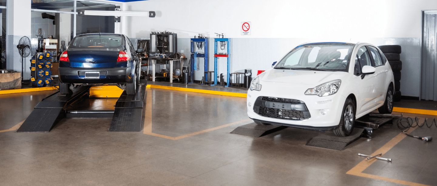 Modern auto repair shop with two cars on lifts for maintenance and repairs.