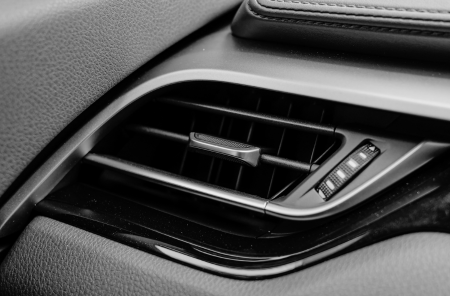 Car air vent showing heating and cooling controls for climate regulation.