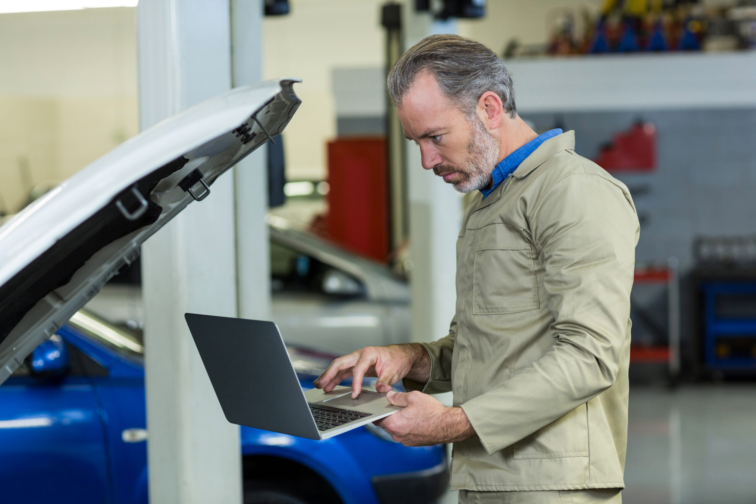 Mechanic using laptop in repair garage