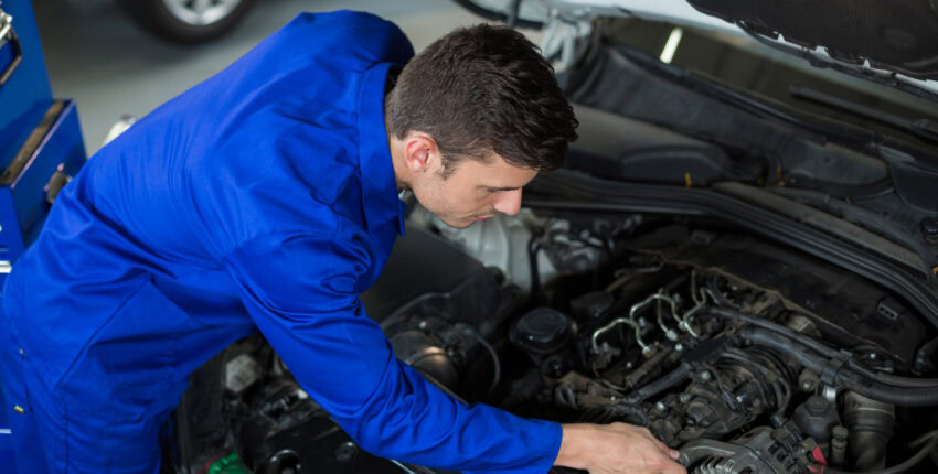 Technician inspecting car engine during maintenance at Franconia Auto Care.