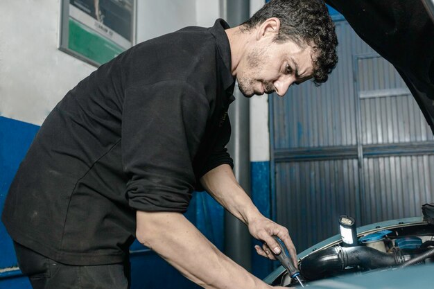 Auto mechanic inspecting timing belt or chain in vehicle engine bay.