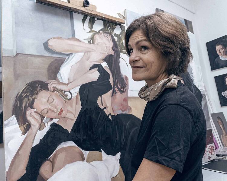 Artist creating a contemporary portrait painting in art studio.