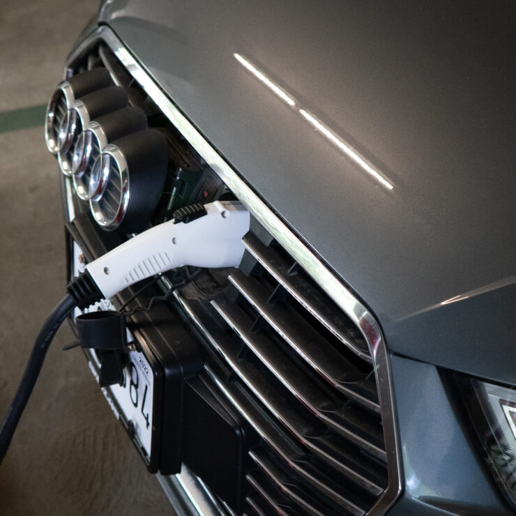 Close-up of an electric vehicle charging port with charging cable attached.