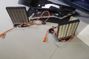 EV battery inspection components on workshop floor for electric vehicle service.