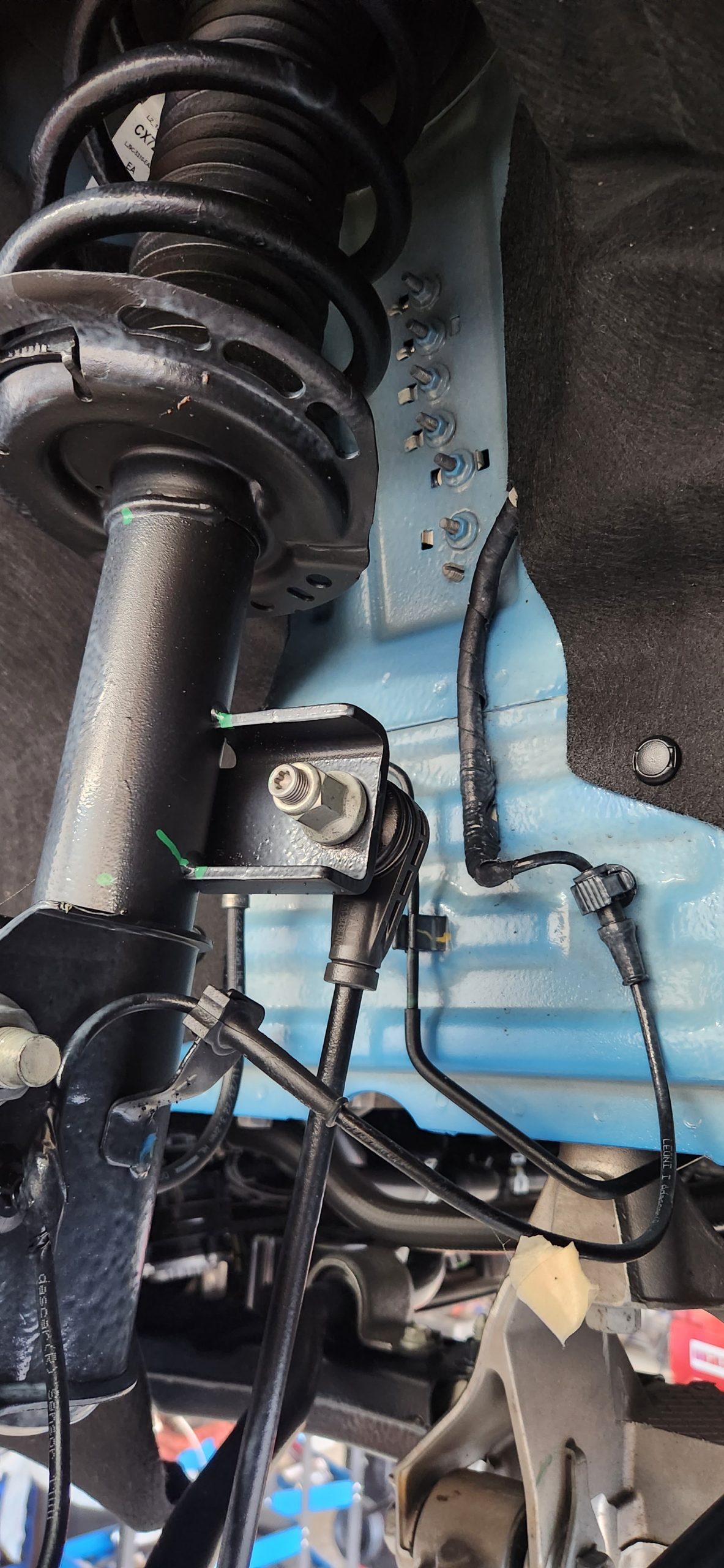 Close-up of vehicle suspension and shock absorber at Garage-EV Dartmouth.