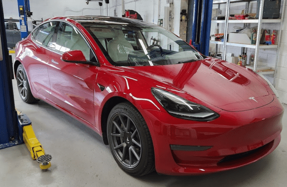 Red Tesla Model 3 in service bay at Garage-EV Dartmouth.