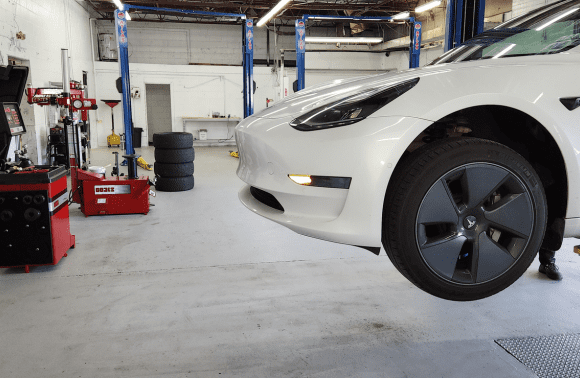 Tesla electric vehicle on lift at Garage-EV service center in Dartmouth.