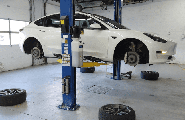 Tesla Model 3 on lift at Garage-EV electric vehicle service center.