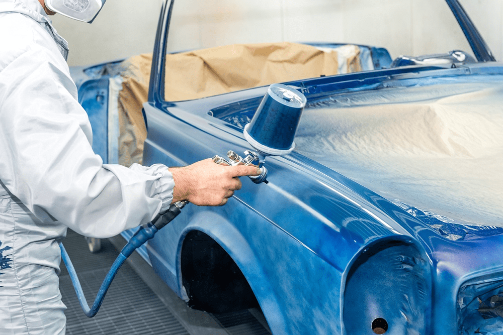 Technician applying protective coating to a classic car at Garage-EV Dartmouth.