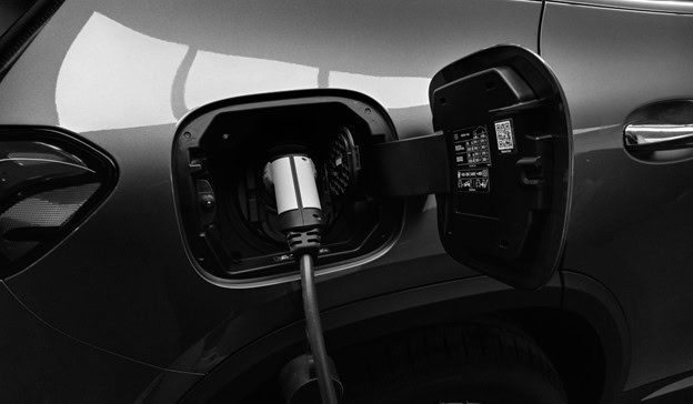 Electric vehicle charging port with charging cable connected.