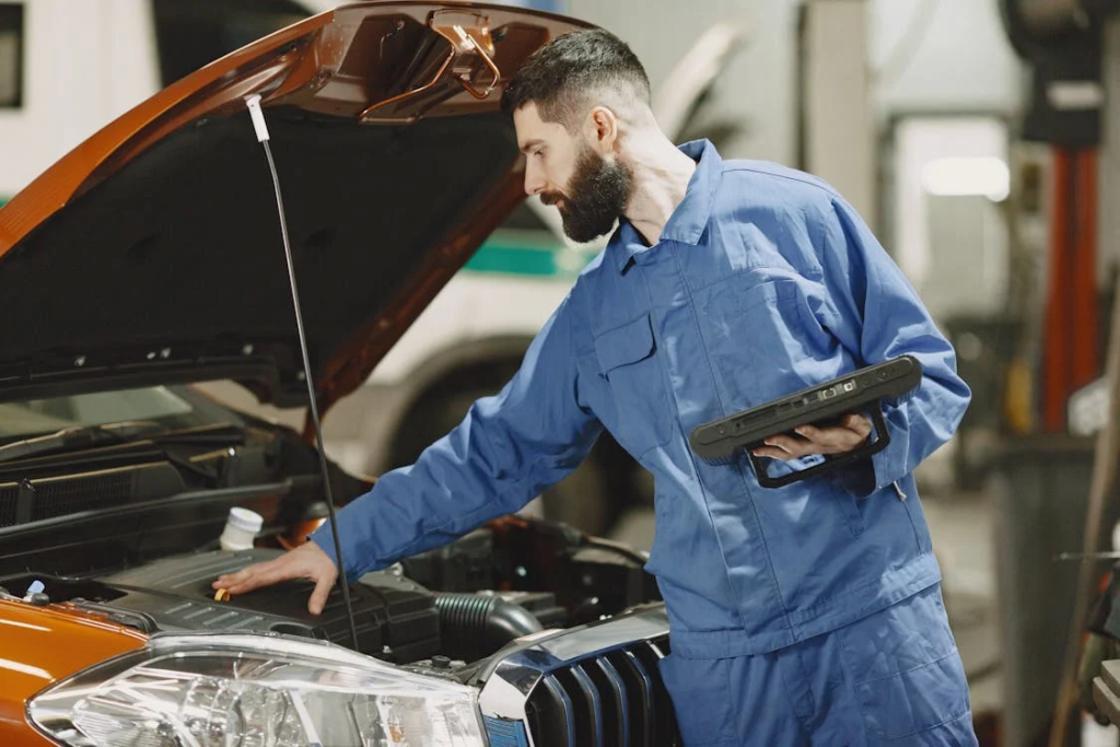 Technician inspecting an electric vehicle engine in a service center.