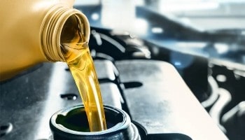 Engine oil being poured into a car engine for maintenance.