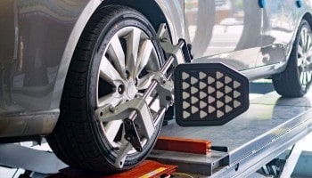 Car wheel being aligned using specialized equipment at Global Car Care.