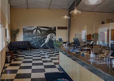 Modern car care reception area with check-in desk and seating.