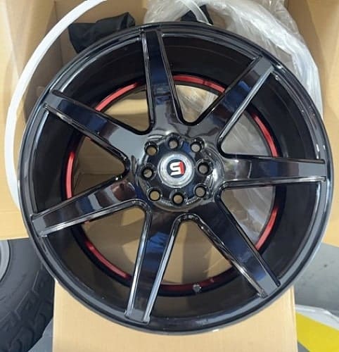 Black alloy car wheel rim with red accents, suitable for sports cars and upgrades.
