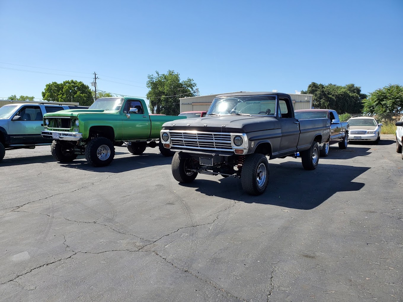 Classic lifted trucks at Grumpy's Hot Rod, vintage car enthusiasts' paradise.