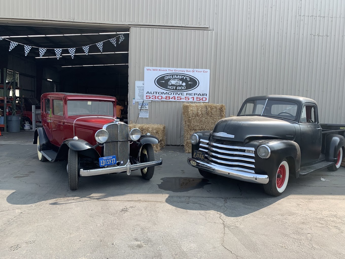 Classic vintage hot rods parked outside Grumpy's Hot Rod, showcasing restored and customized vehicle.