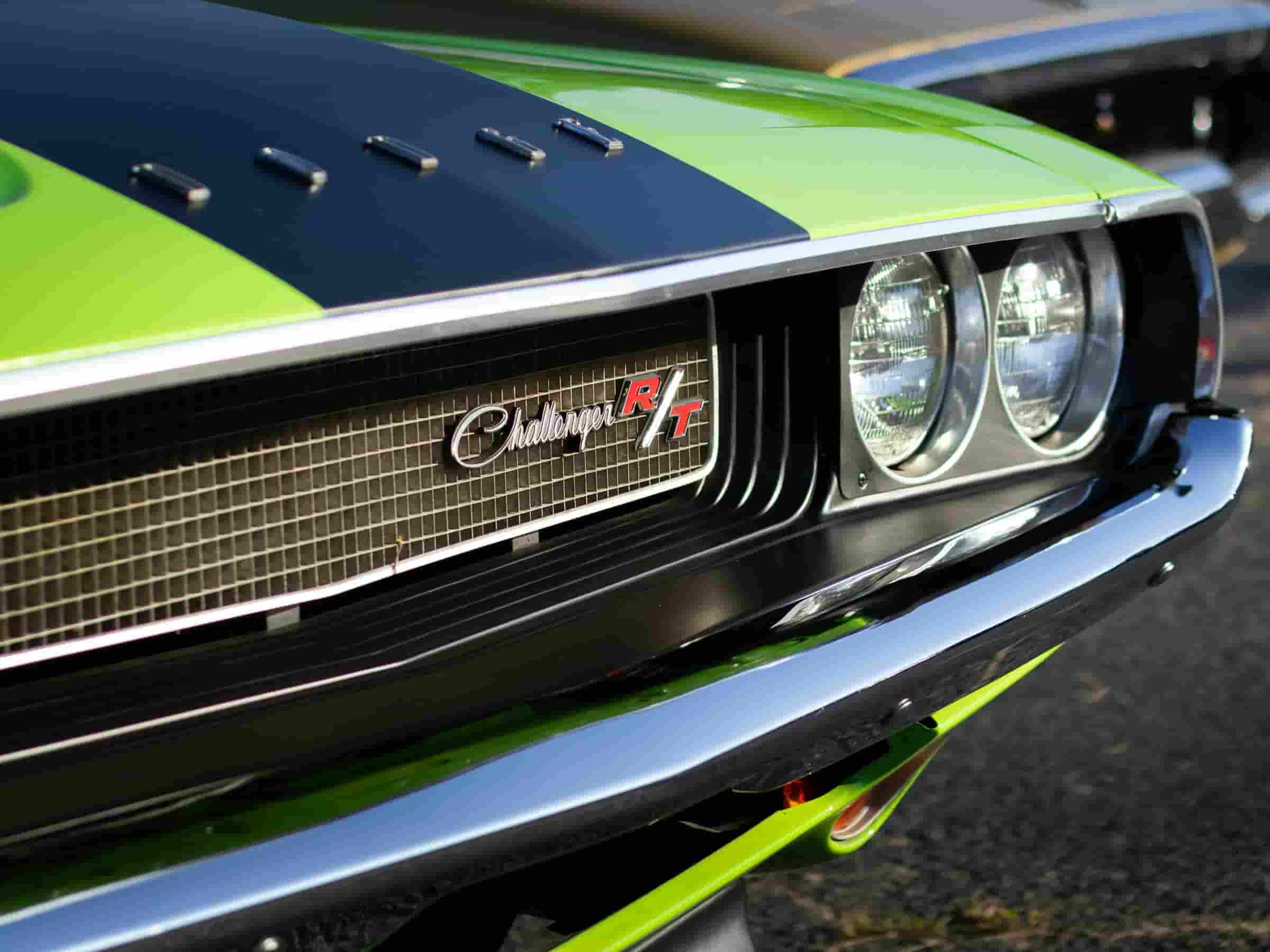 Close-up of a green Challenger R/T hot rod engine front grille and headlights.